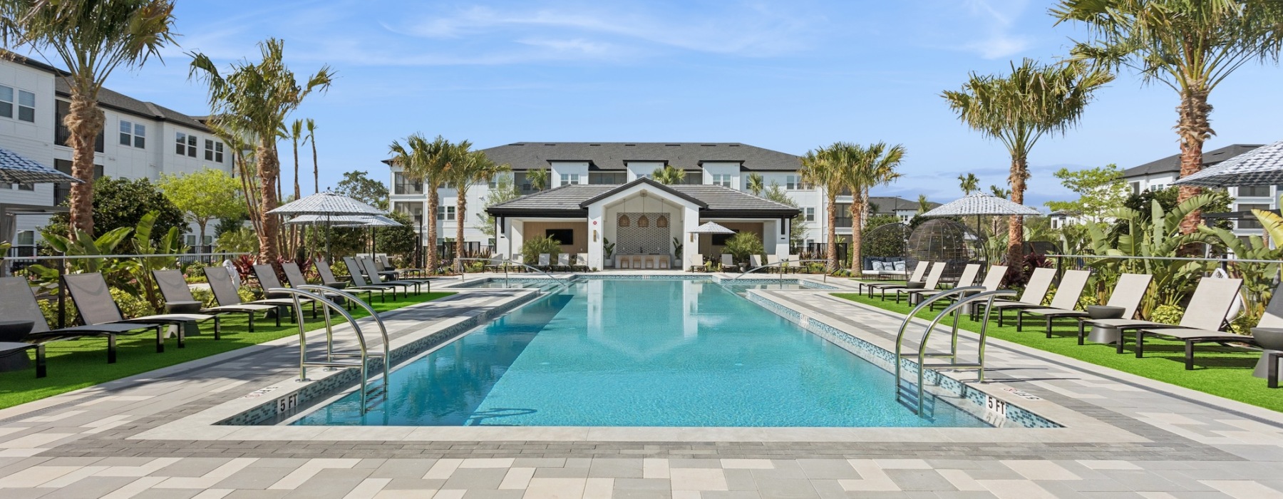 a swimming pool with palm trees and a building in the background